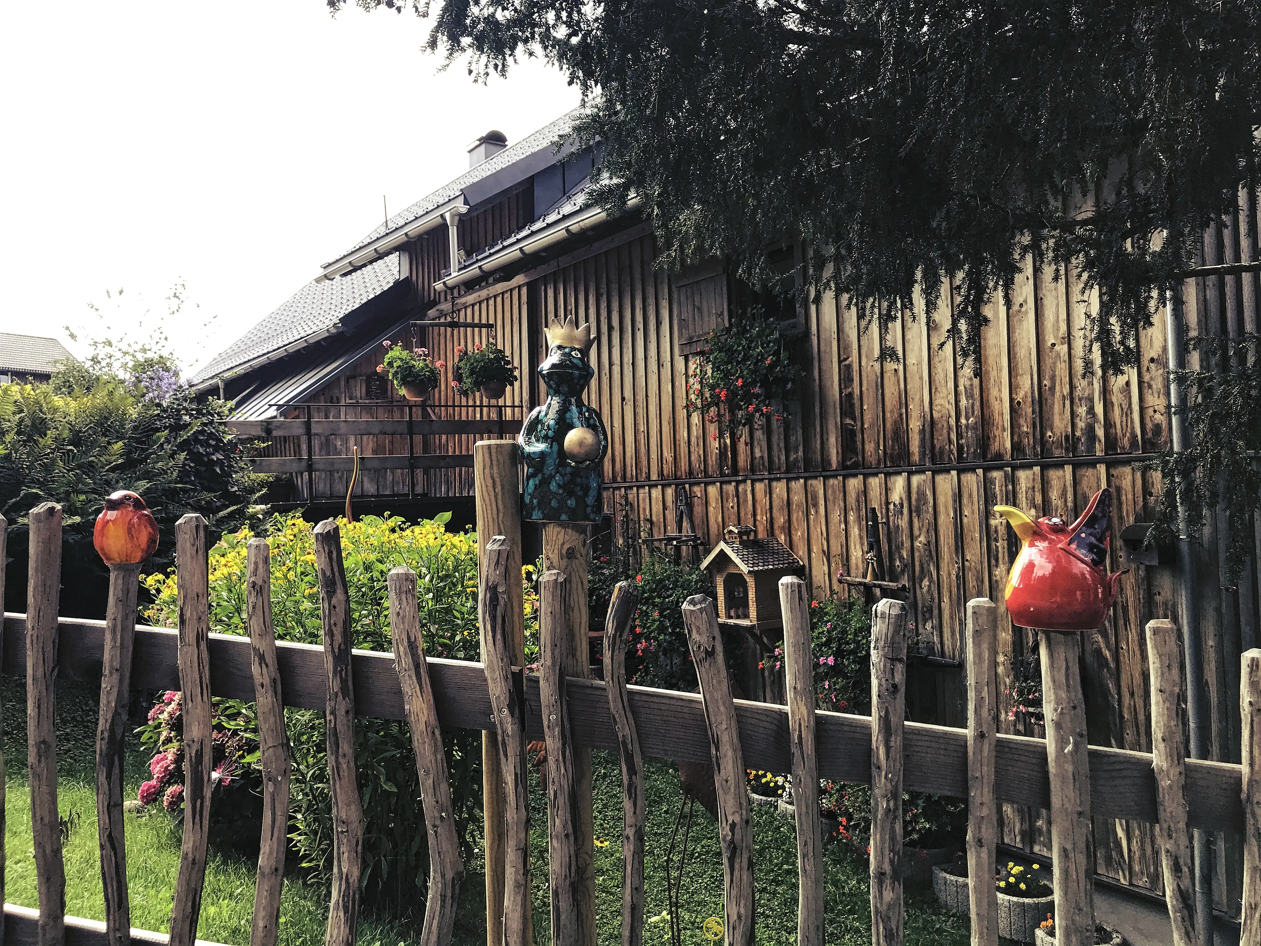 Eines der Bauernhäuser bei Bregenz hat einen mit Keramikfiguren geschmückten Gartenzaun.